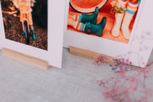 Matted prints displayed on wood stands